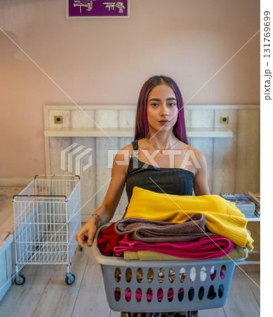Young Man Carrying Basket of Folded Clothes 131769699