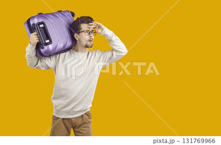 Man tourist carrying suitcase on his shoulder and looking into distance 131769966