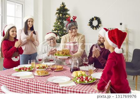 Happy grandmother serving turkey on table during Christmas family dinner at home Happy grandmother serving turkey on table during Christmas family dinner at home 131769976