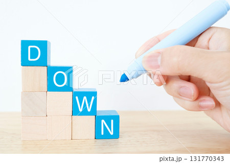 青いブロックで右下に下がるDOWNの文字。減少イメージ。 131770343