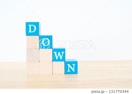 青いブロックで右下に下がるDOWNの文字。減少イメージ。 131770344