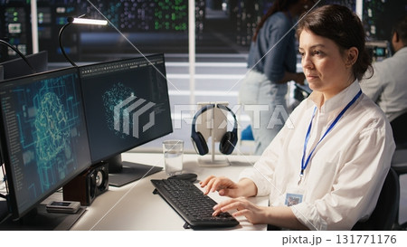 Data center technician monitors server rigs performing AI training and inference tasks. Server hub IT professional oversees high tech systems managing deep learning storage operations, camera A Data center technician monitors server rigs performing AI training and inference tasks. Server hub IT professional oversees high tech systems managing deep learning storage operations, camera A 131771176