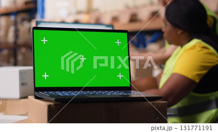 Logistics employee organizing packages near isolated mockup on computer, inserting order tracking tools and labeling systems. Staff member analyzing business inventory dashboards. Camera B. Logistics employee organizing packages near isolated mockup on computer, inserting order tracking tools and labeling systems. Staff member analyzing business inventory dashboards. Camera B. 131771191