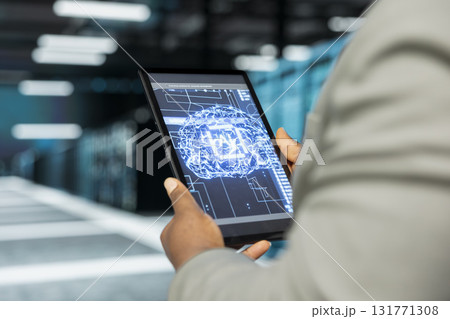 Close up of data center admin using artificial intelligence computerized model on tablet simulating human brain. Server farm IT professional working with AI machine learning algorithms on device 131771308