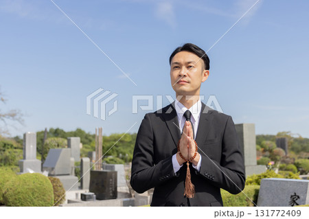 お墓参りをする男性 131772409