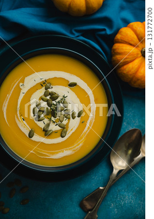 Pumpkin soup in a blue bowl, blue background. Autumn food 131772700