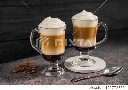 Layered coffee latte drinks. Hot coffee drinks in glass mugs, dark background Layered coffee latte drinks. Hot coffee drinks in glass mugs, dark background 131772725