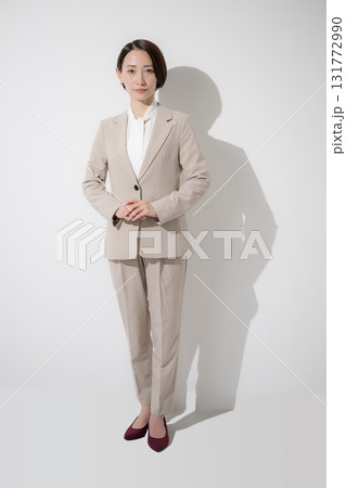 ベージュのスーツを着た営業など、美人な女性のビジネス全身 立つのカメラ目線成白背景 ベージュのスーツを着た営業など、美人な女性のビジネス全身 立つのカメラ目線成白背景 131772990