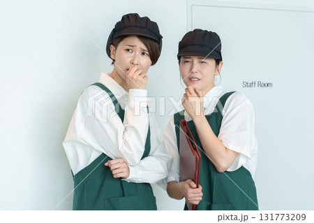 内緒話をするアルバイトスタッフ 131773209