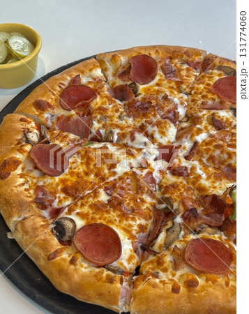 A delicious pizza with a golden crust, melted cheese, and savory toppings. Perfect for food-related designs, menus, or Italian-themed projects, capturing the essence of a classic comfort dish. 131774060