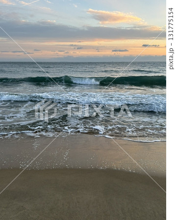 A stunning beach sunset, with vibrant hues of orange, pink, and purple reflecting on the water. Perfect for travel photography, capturing the beauty and tranquility of coastal evening A stunning beach sunset, with vibrant hues of orange, pink, and purple reflecting on the water. Perfect for travel photography, capturing the beauty and tranquility of coastal evening 131775154