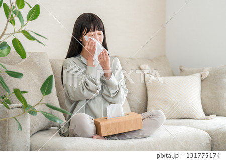 ソファーでテレビや映画を見て涙を拭く若いアジア人女性 ソファーでテレビや映画を見て涙を拭く若いアジア人女性 131775174