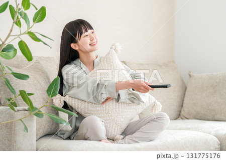 リビングのソファーに座りテレビ鑑賞する若いアジア人女性 リビングのソファーに座りテレビ鑑賞する若いアジア人女性 131775176