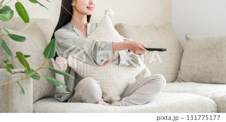 リビングのソファーに座りテレビ鑑賞する若いアジア人女性 リビングのソファーに座りテレビ鑑賞する若いアジア人女性 131775177