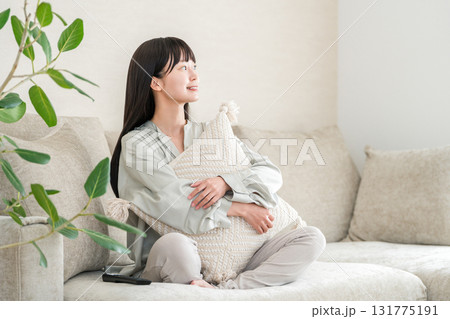 自宅のリビングのソファーでくつろぐ笑顔の若いアジア人女性 131775191
