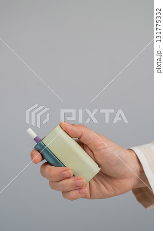 Woman holding electronic cigarette on white background. Tobacco heating systems. 131775332