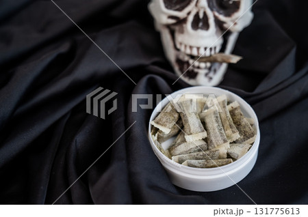 Skull Chewing Tobacco on Black Cloth. Skull Chewing Tobacco on Black Cloth. 131775613