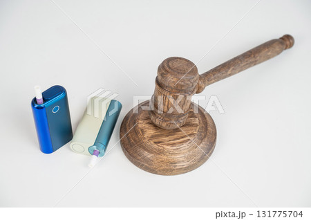 Judge's gavel and electronic cigarette. Smoking ban. Tobacco heating systems. Judge's gavel and electronic cigarette. Smoking ban. Tobacco heating systems. 131775704