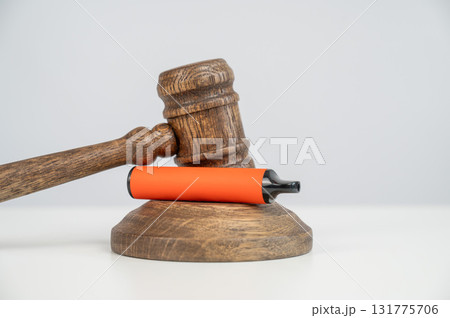 Judge's gavel hits disposable vape. Smoking ban. 131775706