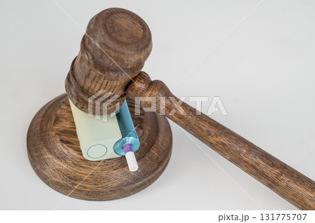 Judge's gavel hits e-cigarette. Smoking ban. Tobacco heating systems. Judge's gavel hits e-cigarette. Smoking ban. Tobacco heating systems. 131775707