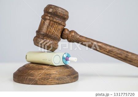 Judge's gavel hits e-cigarette. Smoking ban. Tobacco heating systems. Judge's gavel hits e-cigarette. Smoking ban. Tobacco heating systems. 131775720