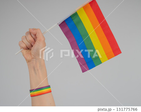 A woman holds a rainbow flag in her fist. A symbol of the fight for equality. 131775766