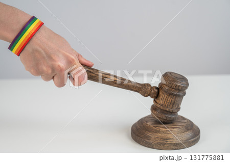 Judge hits gavel on rainbow bracelet.  131775881