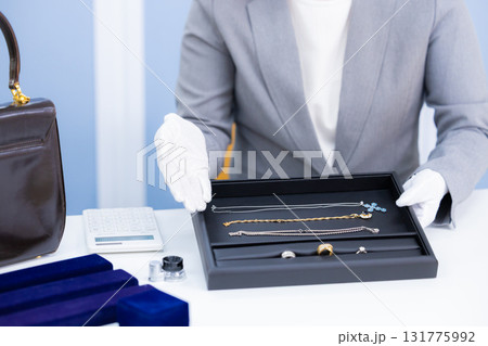 買取業者 窓口で査定をしている女性の手元 買取業者 窓口で査定をしている女性の手元 131775992