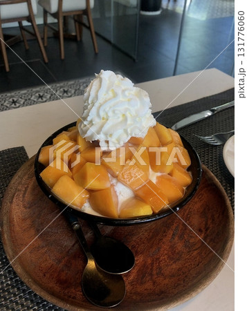 Refreshing mango bingsu with fluffy shaved ice, sweet mango chunks, and creamy condensed milk. A perfect Korean dessert for hot days, offering a delightful balance of fruity and creamy flavors! Refreshing mango bingsu with fluffy shaved ice, sweet mango chunks, and creamy condensed milk. A perfect Korean dessert for hot days, offering a delightful balance of fruity and creamy flavors! 131776060