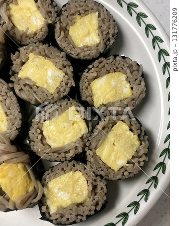 Delicious kimbap rolls filled with fresh vegetables, seasoned rice, and savory proteins, all wrapped in crisp seaweed. A perfect combination of flavor and texture in every bite. 131776209