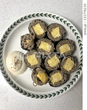 Delicious kimbap rolls filled with fresh vegetables, seasoned rice, and savory proteins, all wrapped in crisp seaweed. A perfect combination of flavor and texture in every bite. 131776210