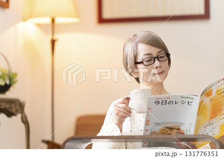 リビングで料理のレシピ本を見るシニア女性 リビングで料理のレシピ本を見るシニア女性 131776351