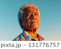 Elderly man with wrinkles in front of clear blue sky illuminated by warm sunlight 131776757