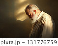 Elderly man with thick white beard standing alone on a neutral background in soft sunlight 131776759
