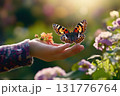 Child gently holds butterfly in a sunny garden filled with colorful flowers 131776764