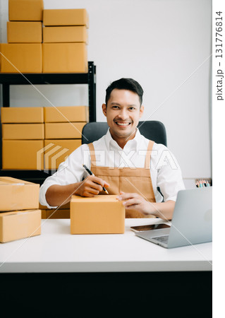 Young man running online store Startup small business SME, using smartphone or tablet taking receive and checking online purchase shopping order 131776814