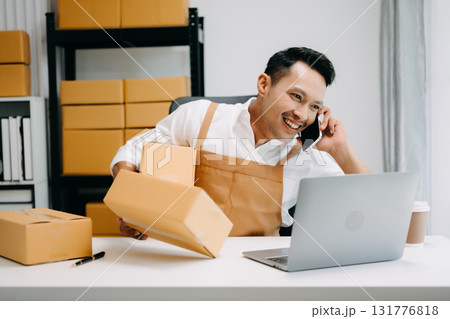 Portrait of Asian man SME working using smartphone or tablet taking receive and checking online purchase shopping order to ,freelance business online concept. 131776818