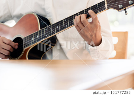ギターを弾く男性の手元 131777283