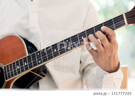 ギターを弾く男性の手元 131777285