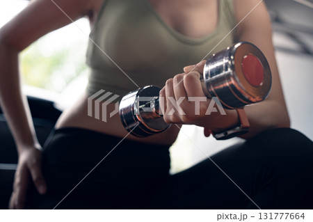 Young asian woman doing exercise and lifting dumbbells weights at sport gym. Young asian woman doing exercise and lifting dumbbells weights at sport gym. 131777664