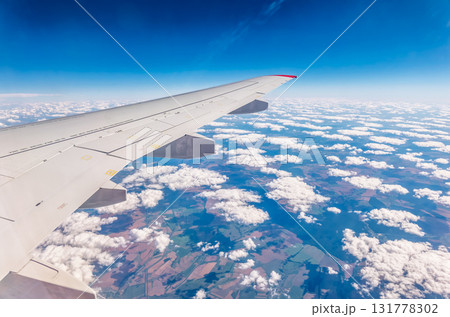 View from the airplane window at a beautiful cloudy sky and the airplane wing 131778302
