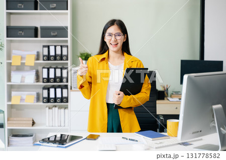 Confident business expert attractive smiling young woman holding digital tablet on desk Confident business expert attractive smiling young woman holding digital tablet on desk 131778582