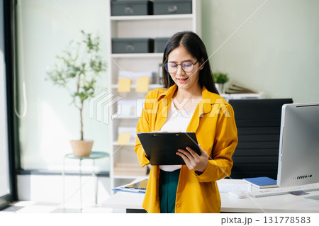 Confident business expert attractive smiling young woman holding digital tablet on desk Confident business expert attractive smiling young woman holding digital tablet on desk 131778583