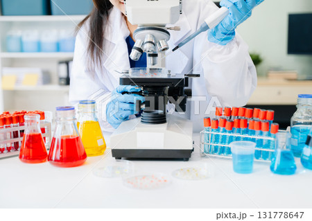female scientist working with micro pipettes analyzing biochemical female scientist working with micro pipettes analyzing biochemical 131778647