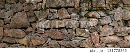 Rustic stone wall with moss in natural outdoor setting - texture and background 131778886