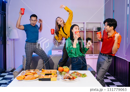 Celebration with friends enjoying food, drinks, and laughter at a lively house party. Perfect for themes of joy Celebration with friends enjoying food, drinks, and laughter at a lively house party. Perfect for themes of joy 131779063