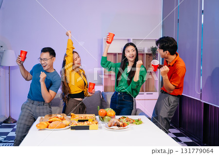 Celebration with friends enjoying food, drinks, and laughter at a lively house party. Perfect for themes of joy Celebration with friends enjoying food, drinks, and laughter at a lively house party. Perfect for themes of joy 131779064