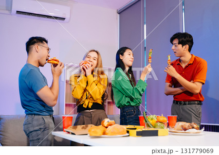 Celebration with friends enjoying food, drinks, and laughter at a lively house party. Perfect for themes of joy Celebration with friends enjoying food, drinks, and laughter at a lively house party. Perfect for themes of joy 131779069