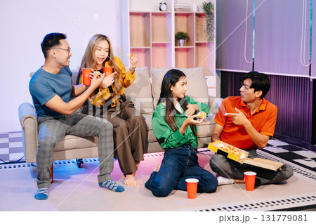 Celebration with friends enjoying food, drinks, and laughter at a lively house party. Perfect for themes of joy Celebration with friends enjoying food, drinks, and laughter at a lively house party. Perfect for themes of joy 131779081
