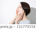頬に手を当てる笑顔の女性のクローズアップ　美容やビューティーなどのイメージの横顔 131779158